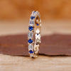Blue sapphire and diamond band crafted in yellow gold with a clean finish.