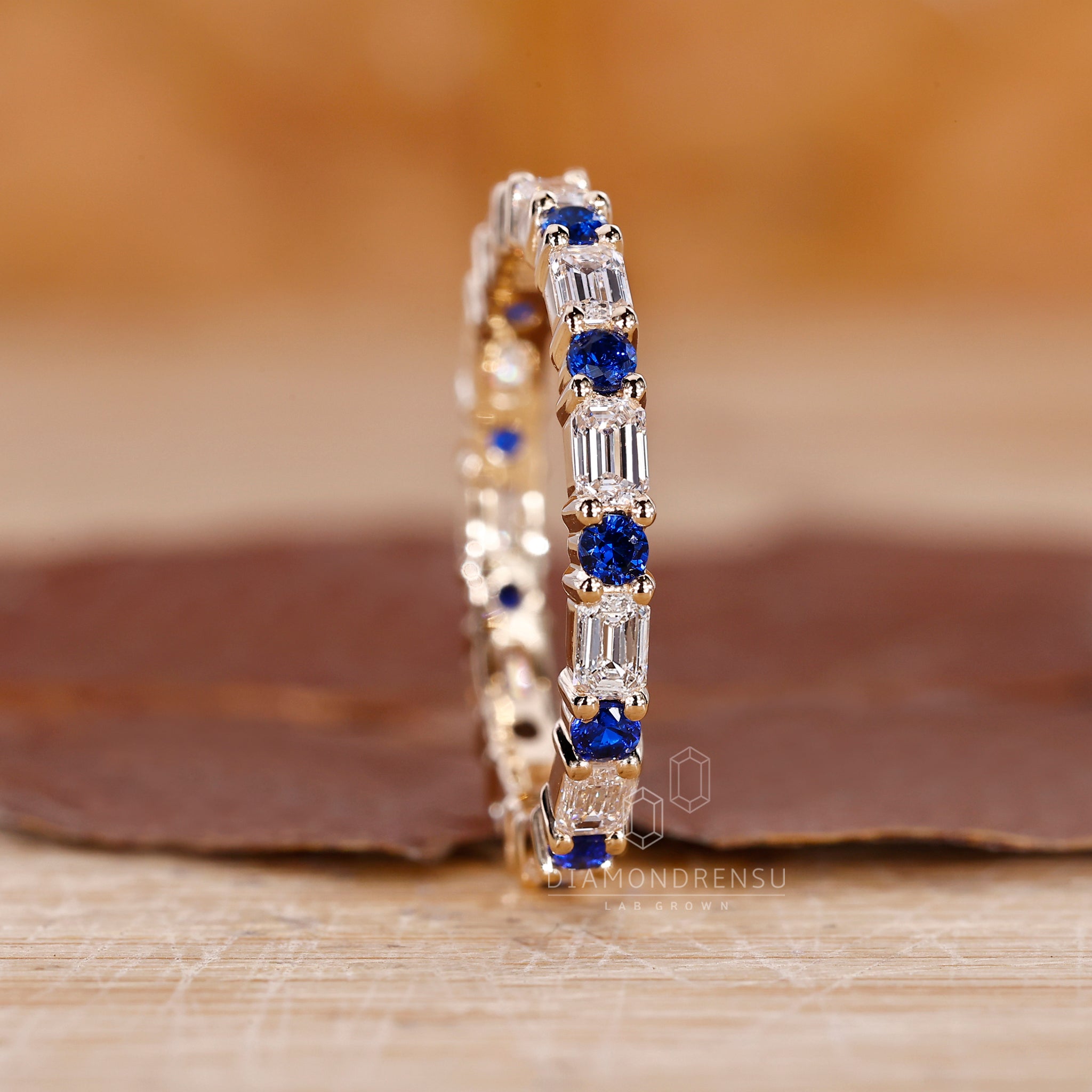 Prong set wedding band combining blue sapphires and lab grown diamonds.