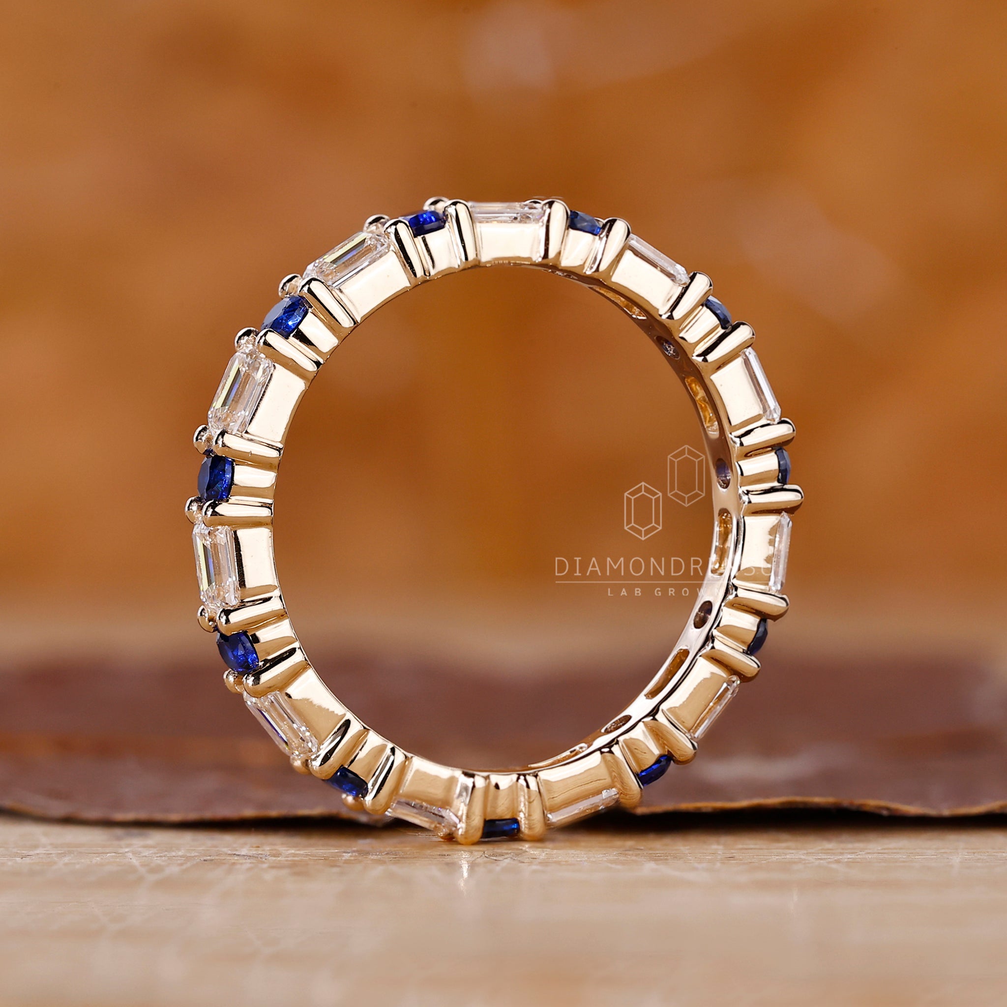 Buy wedding band in yellow gold with bold sapphire and diamond design.