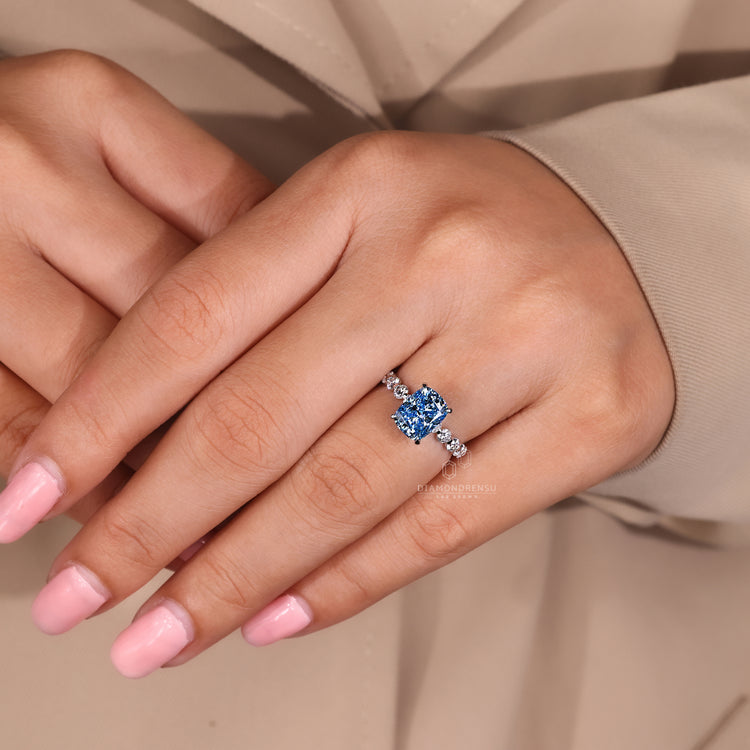 IGI certified cushion blue diamond ring with claw prongs.