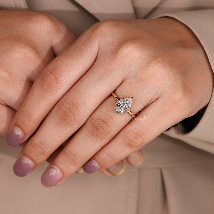 Pear cut diamond ring with round halo side stones.