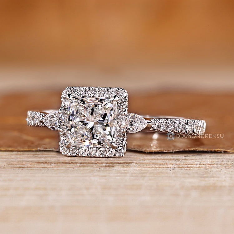 Handmade diamond ring with pear side stone accents.