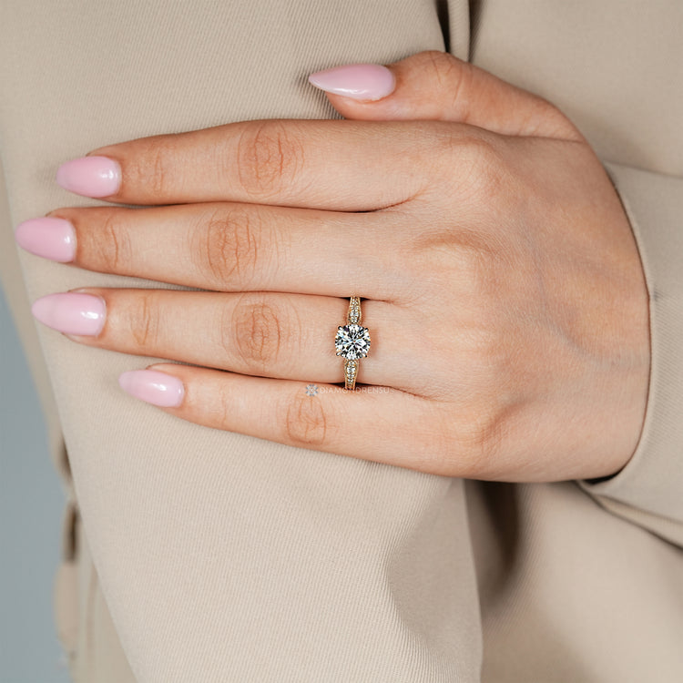 Round diamond ring with pavé setting and pinch shank.