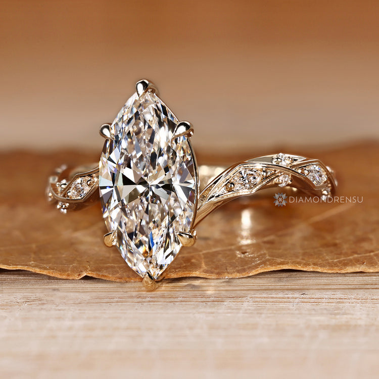 Marquise diamond ring with round side stones and prongs.