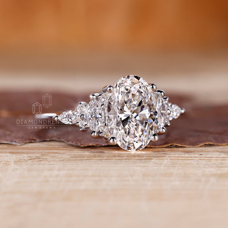 Oval diamond ring with four claw prong and side stones.