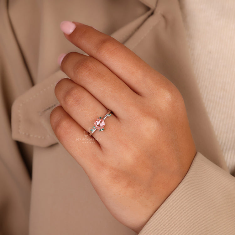 Peach sapphire engagement ring with four prong setting.