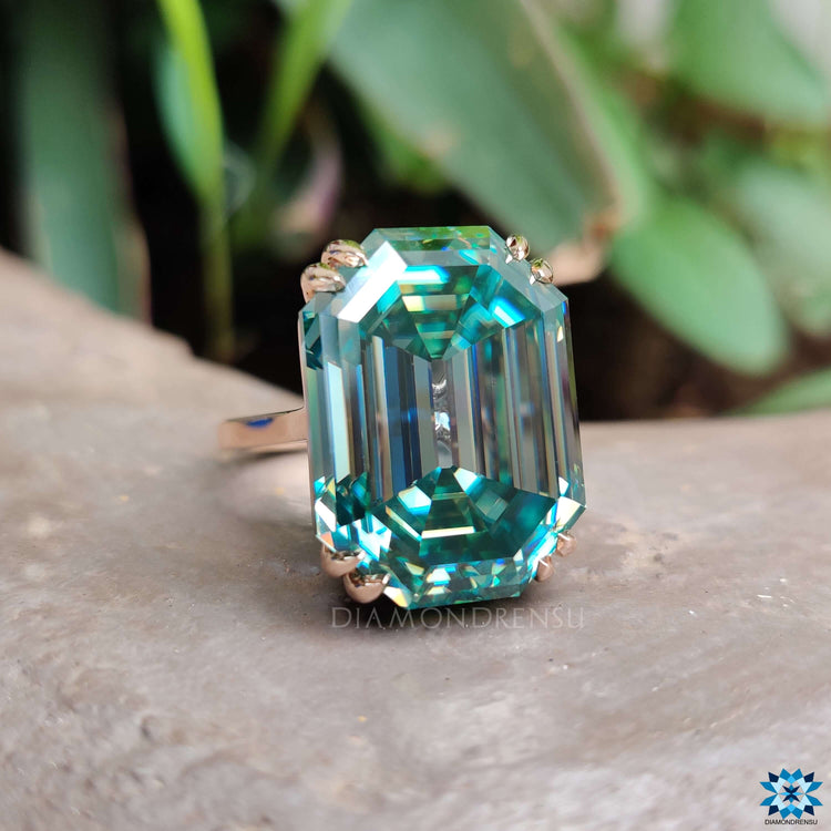 Double claw prong ring featuring cyan blue moissanite.