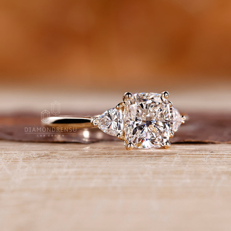 Cushion diamond ring with trillion side stones and cathedral setting.