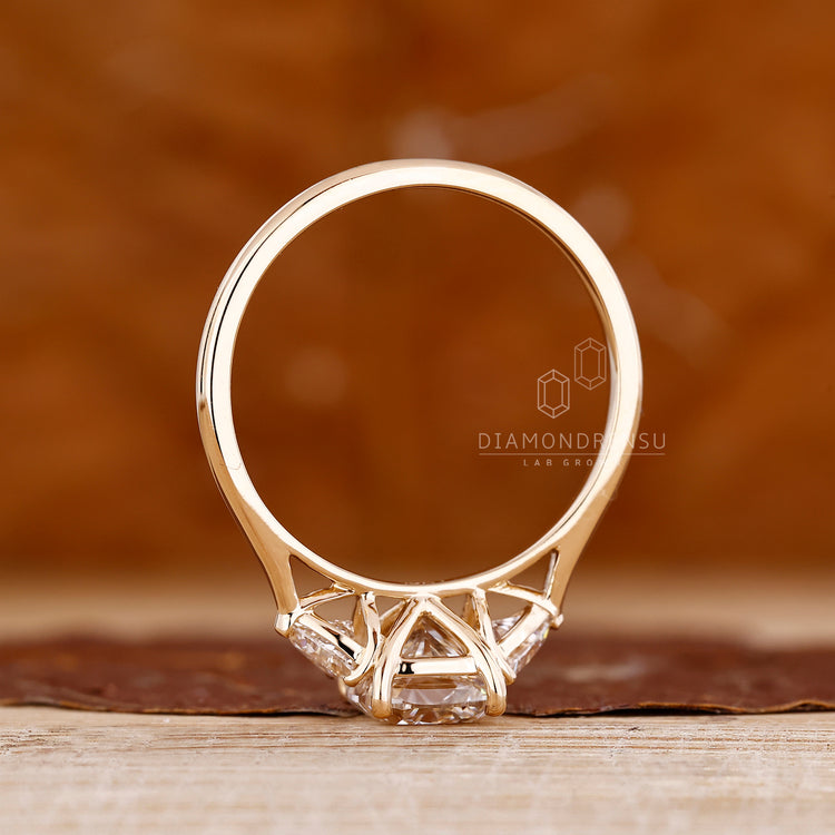 Diamondrensu cushion ring with trillion sides and tapered shank.