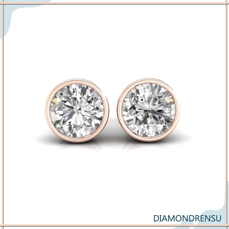 Gold diamond earrings with bezel setting and round cut stones.