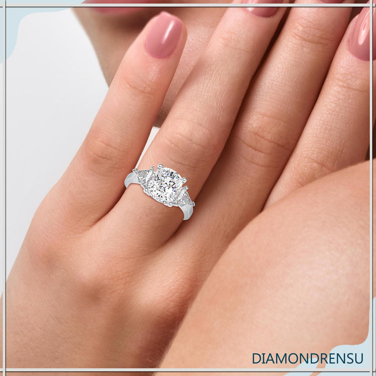 Three stone engagement ring featuring cushion and kite diamonds.