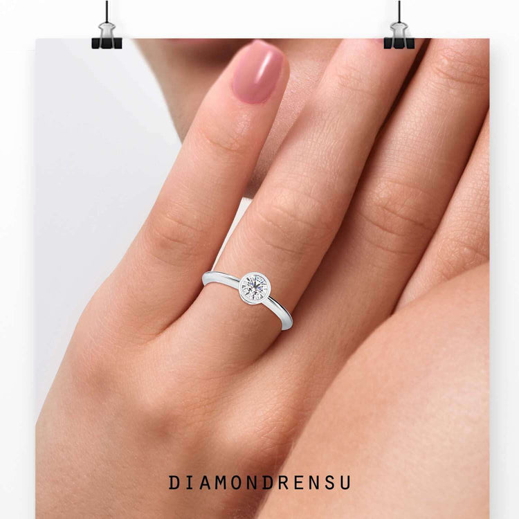 Solitaire bezel ring in white gold with IGI certified diamond.