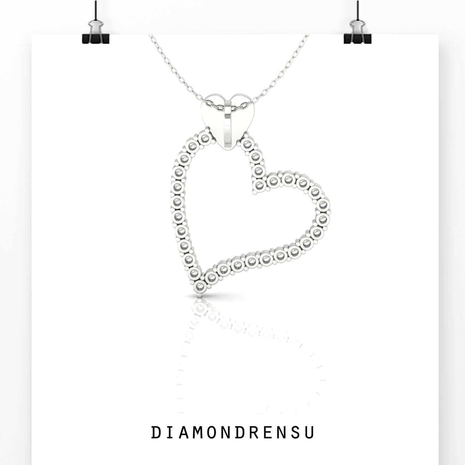 Round diamond pendant inside yellow gold heart frame.