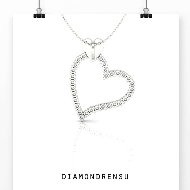Round diamond pendant inside yellow gold heart frame.