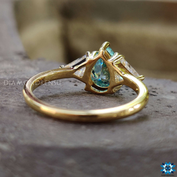 Handmade yellow gold ring with blue moissanite center.