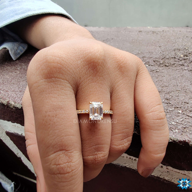 Yellow gold ring with emerald cut center and hidden halo.