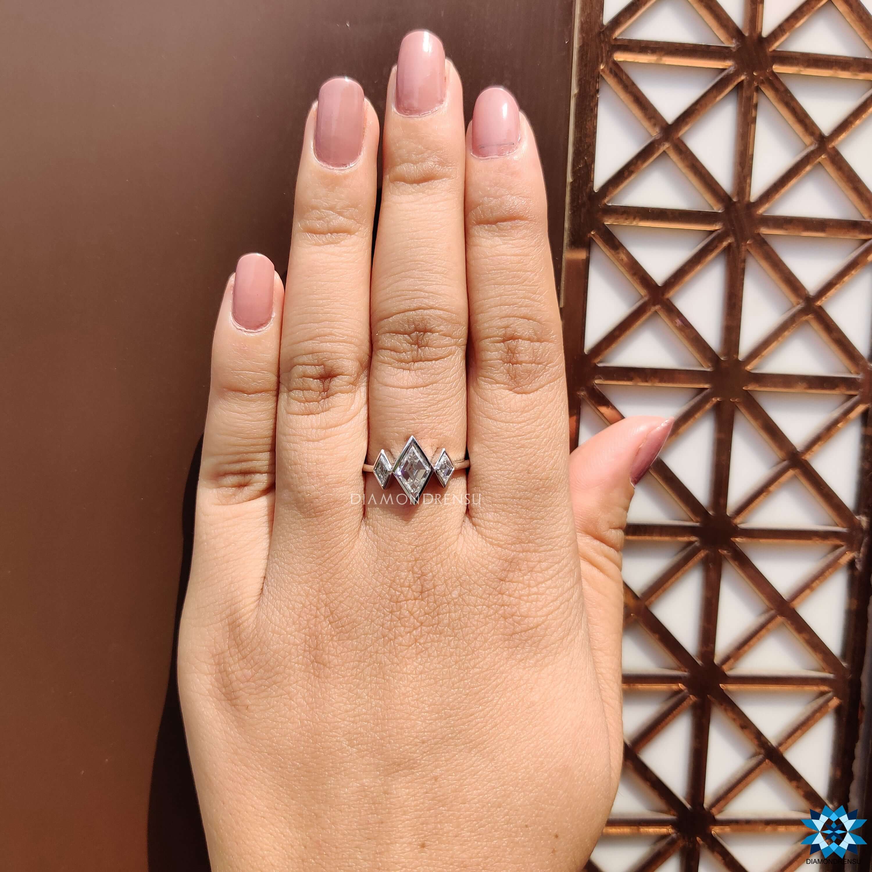 White gold moissanite ring with lozenge cut centerpiece.