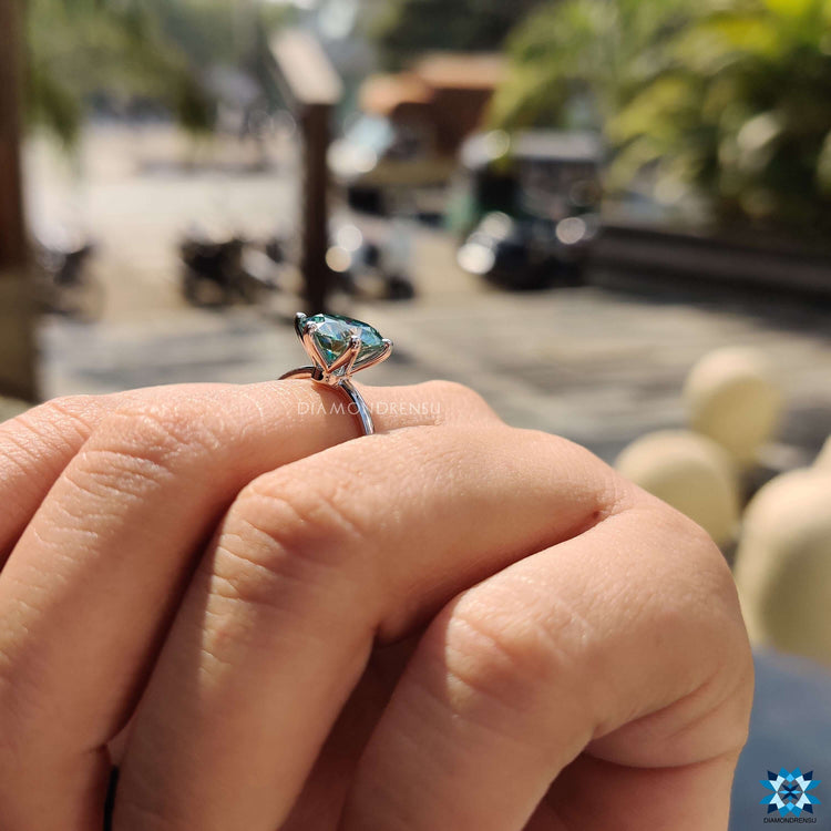 Moissanite engagement ring with a round cut center and handcrafted detailing.