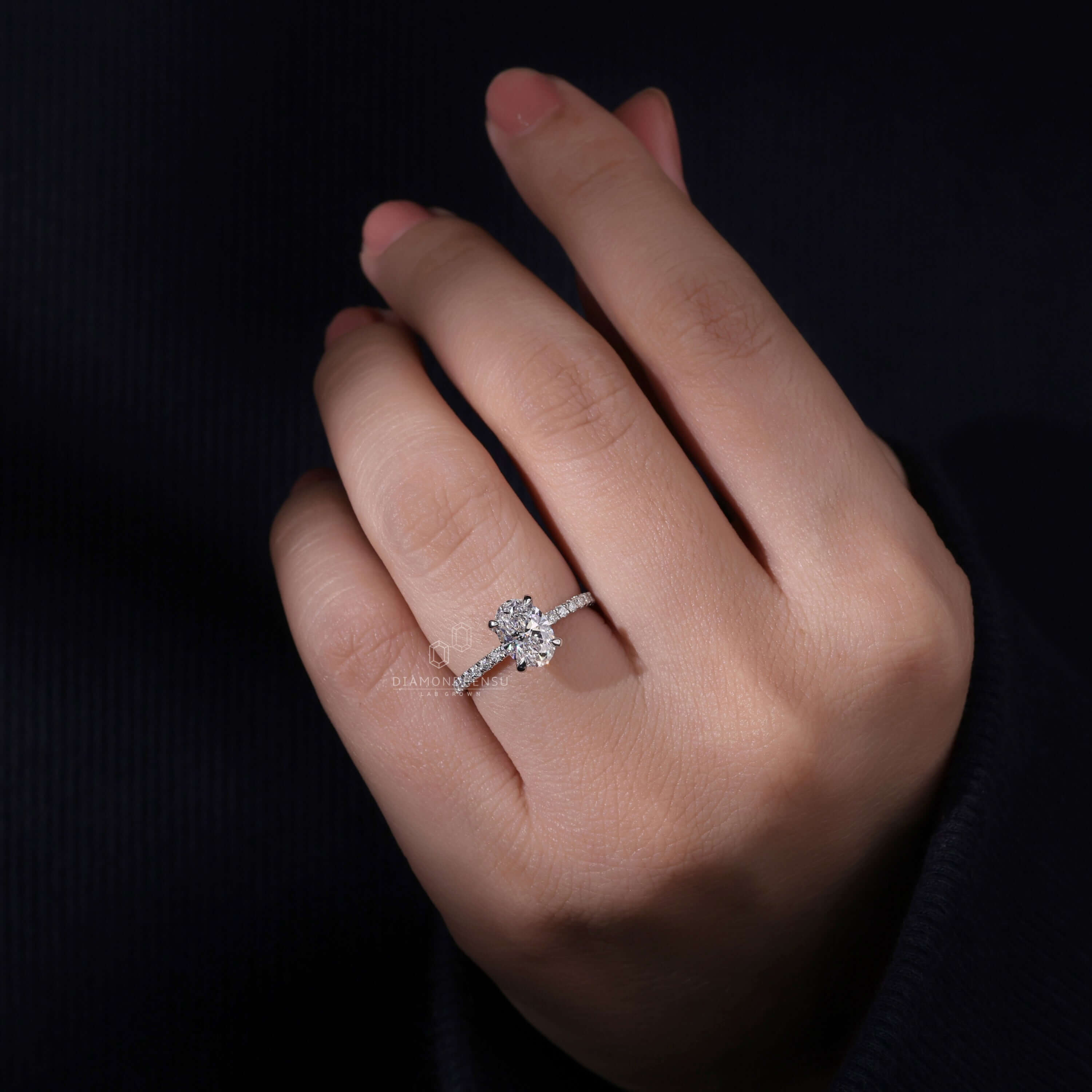 Pave diamond ring with an oval diamond, featuring a 4 prong claw setting for durability and brilliance.