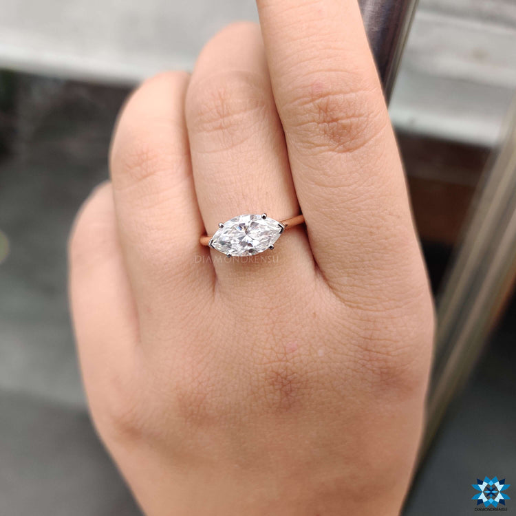 East to west marquise engagement ring with hidden halo accent.