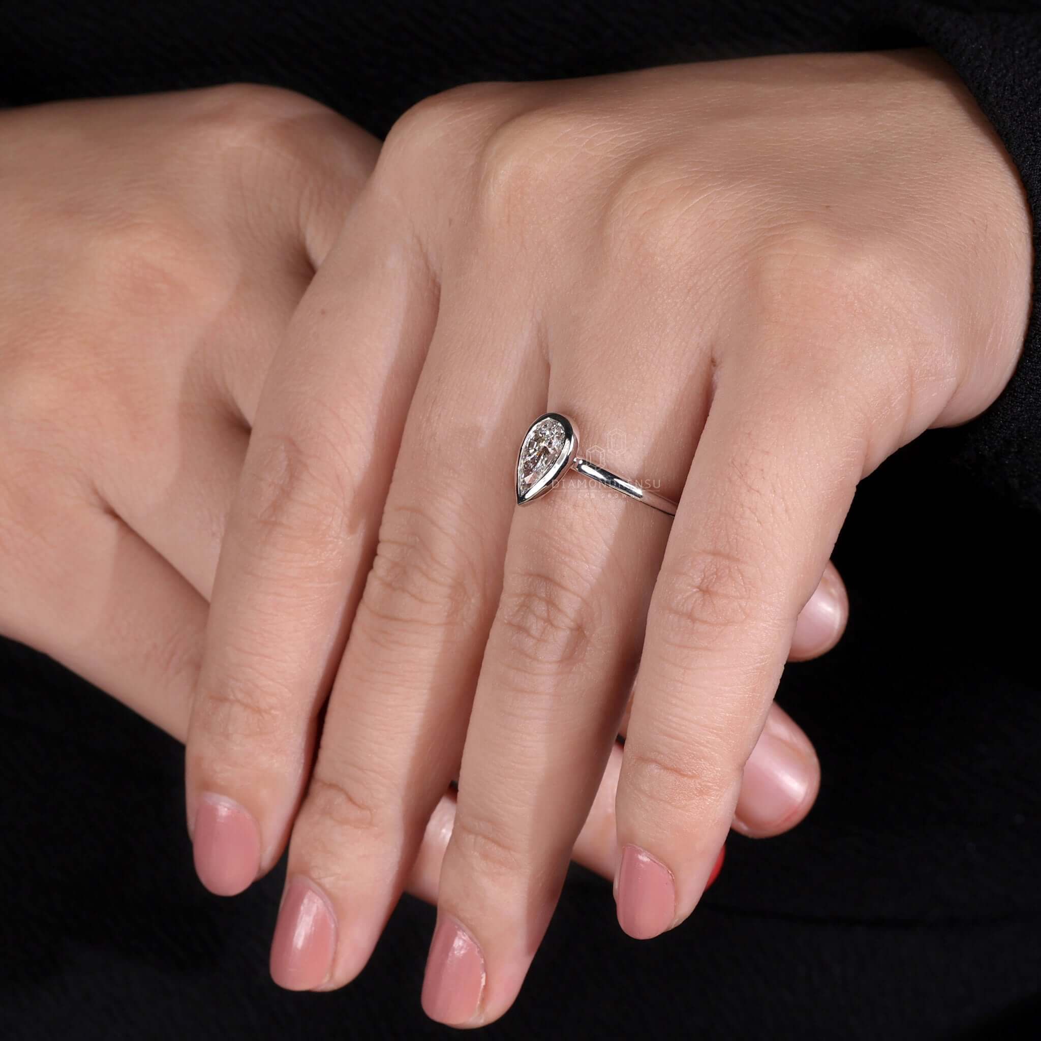 Pear diamond ring with a bezel set diamond for a sleek, modern design