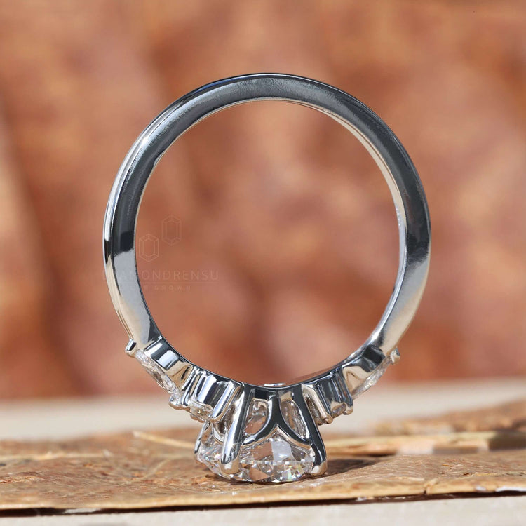 Marquise Side Stone design complements the 4 prong round diamond engagement ring for enhanced beauty and style.