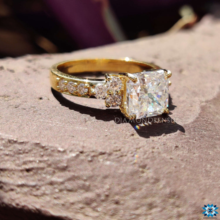 Square radiant cut moissanite ring with side stones.