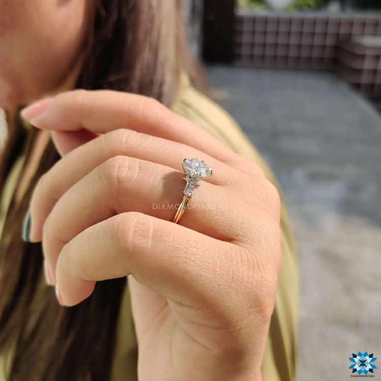 Fishtail prong moissanite engagement ring in two tone gold.