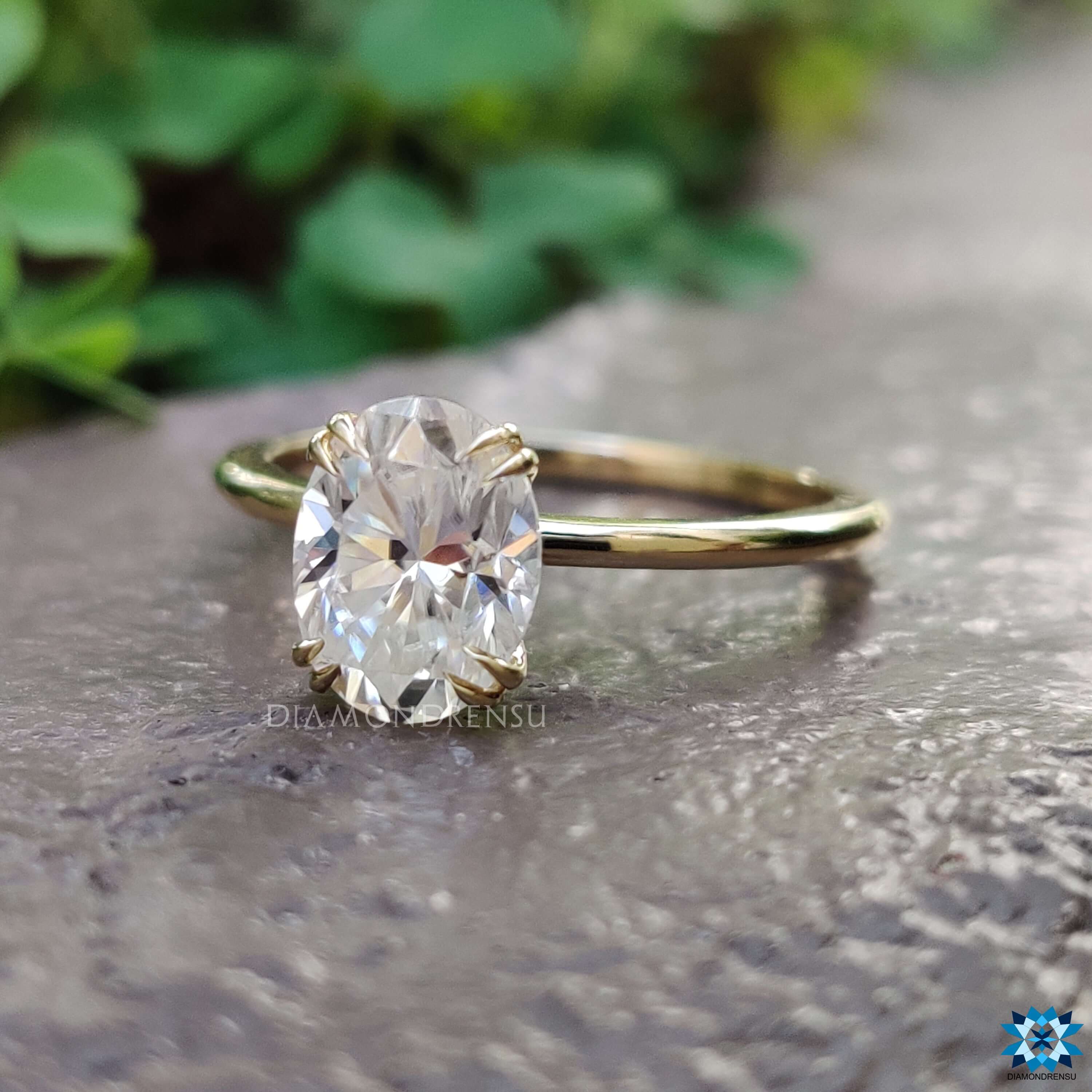 Oval solitaire moissanite ring in custom yellow gold mount.