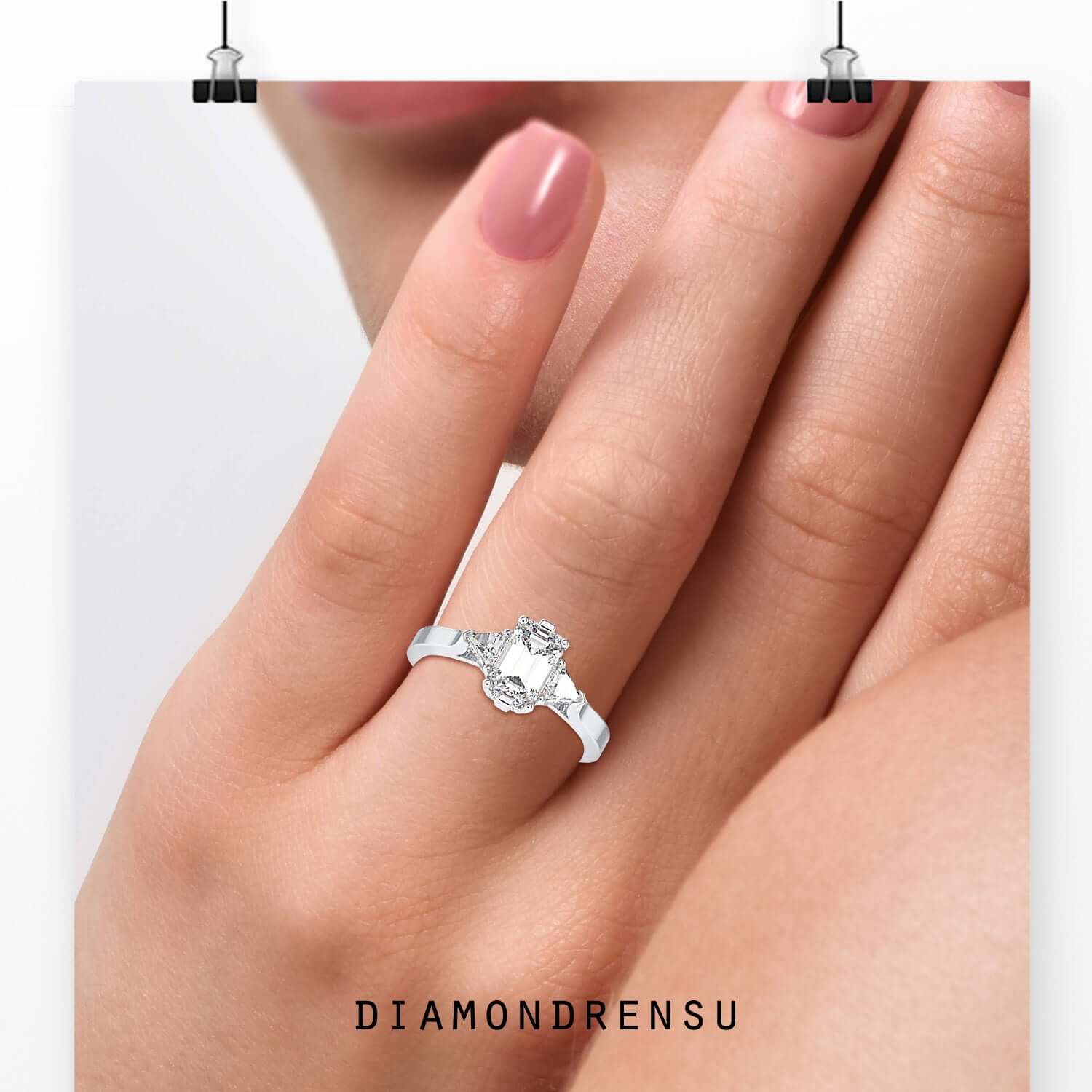 Emerald cut centre diamond ring with prong setting.