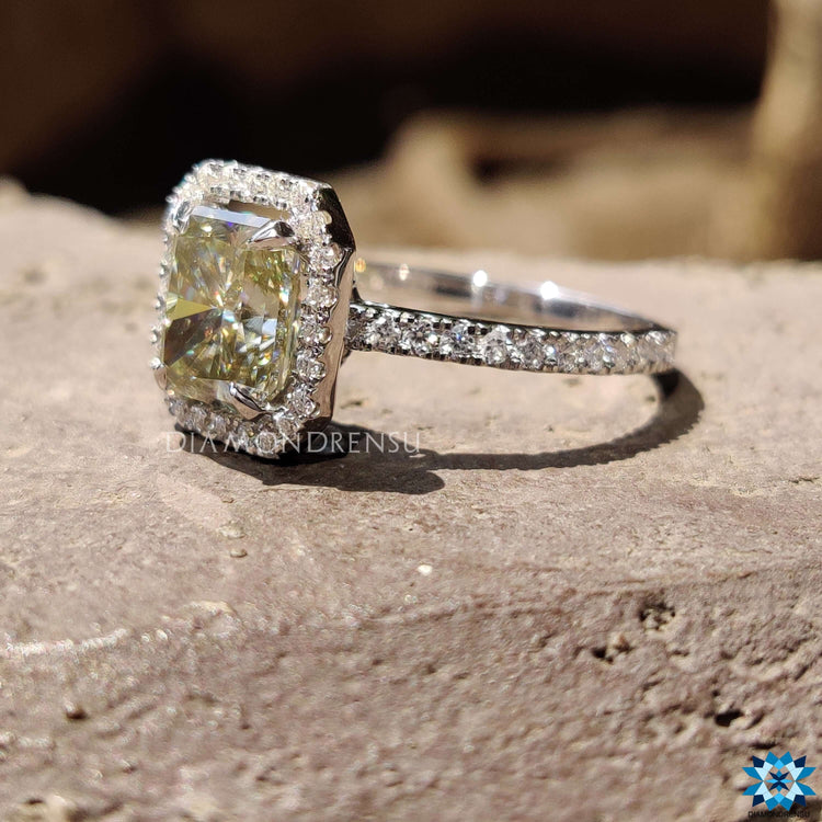 Greenish yellow moissanite engagement ring featuring a 4 prong claw setting.