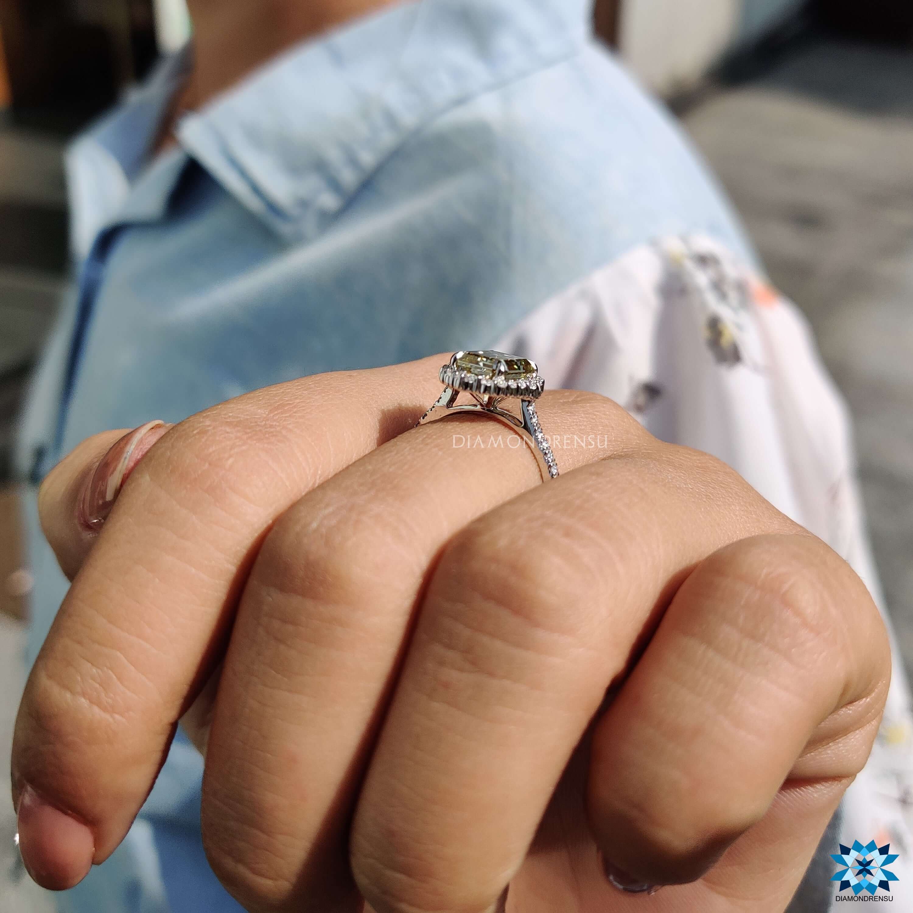Emerald cut moissanite ring with round pave halo design.