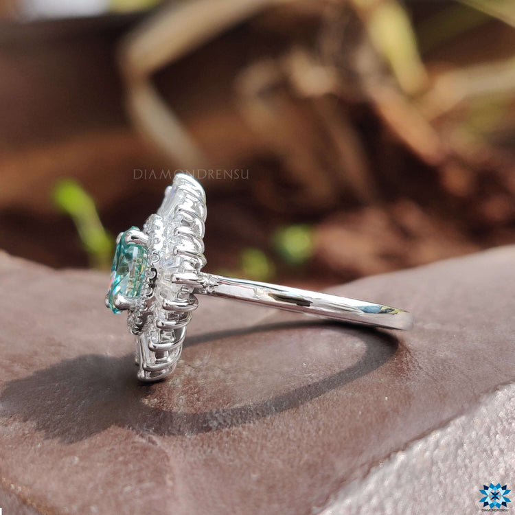 Cyan blue moissanite set in round and baguette halo.