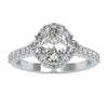 Gold oval diamond engagement ring with cluster halo setting.