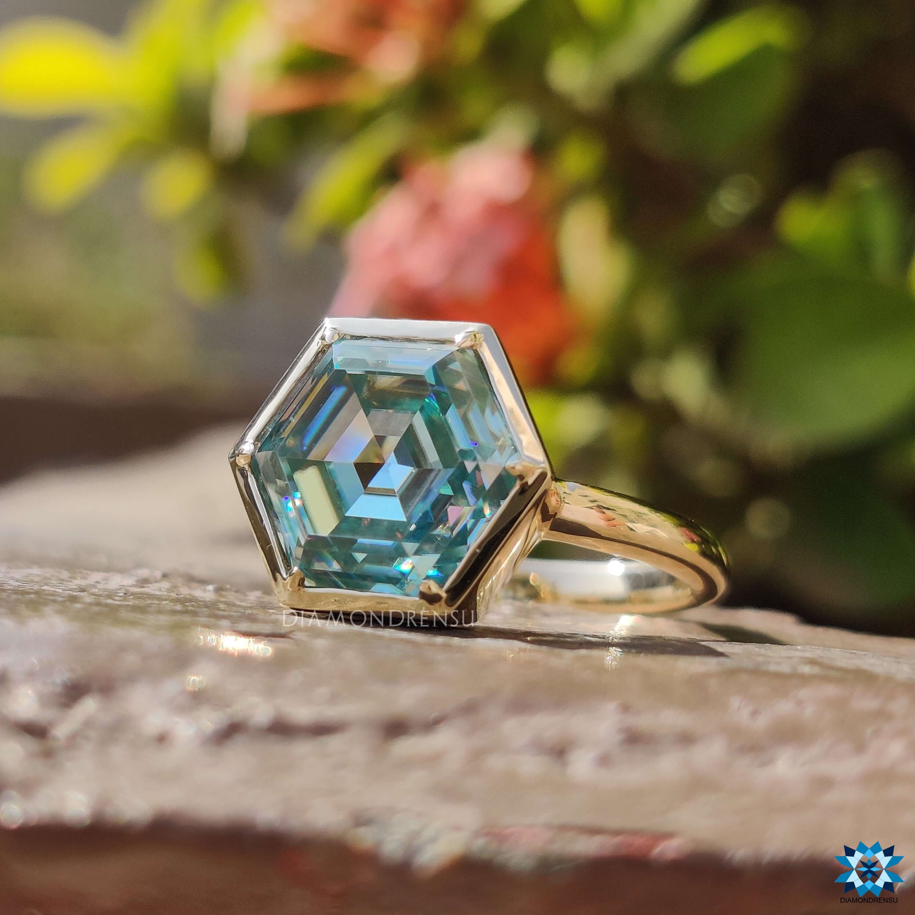 Custom engagement ring featuring bezel set hexagon cut cyan blue moissanite.