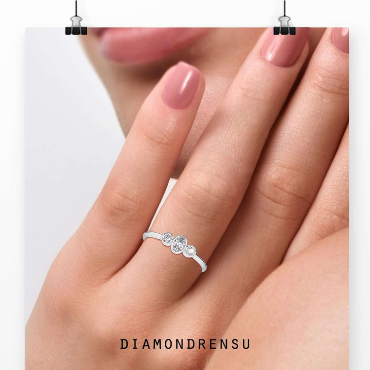 Oval diamond centre stone with two round side diamonds in rose gold.