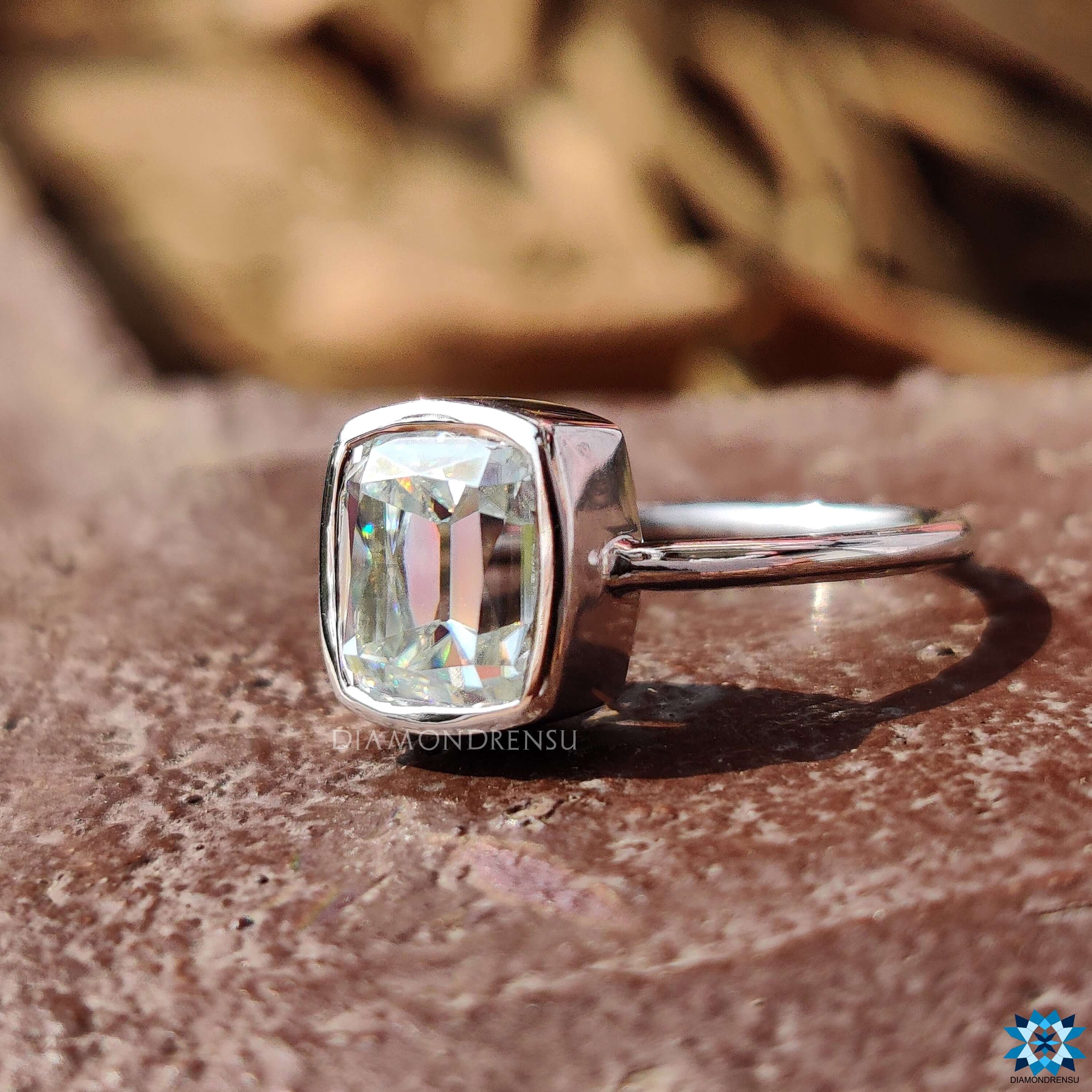 Bezel set cushion moissanite ring with solitaire design.