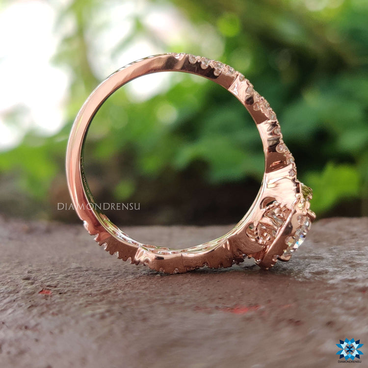 Moissanite halo ring with pear cut center and round pave.