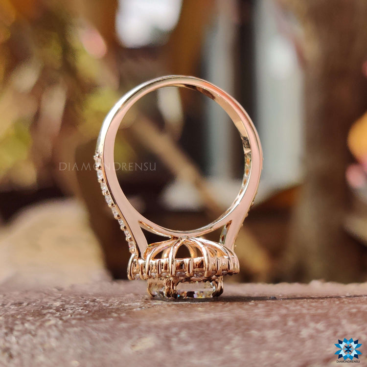 Moissanite halo ring with rose gold band and prong details.