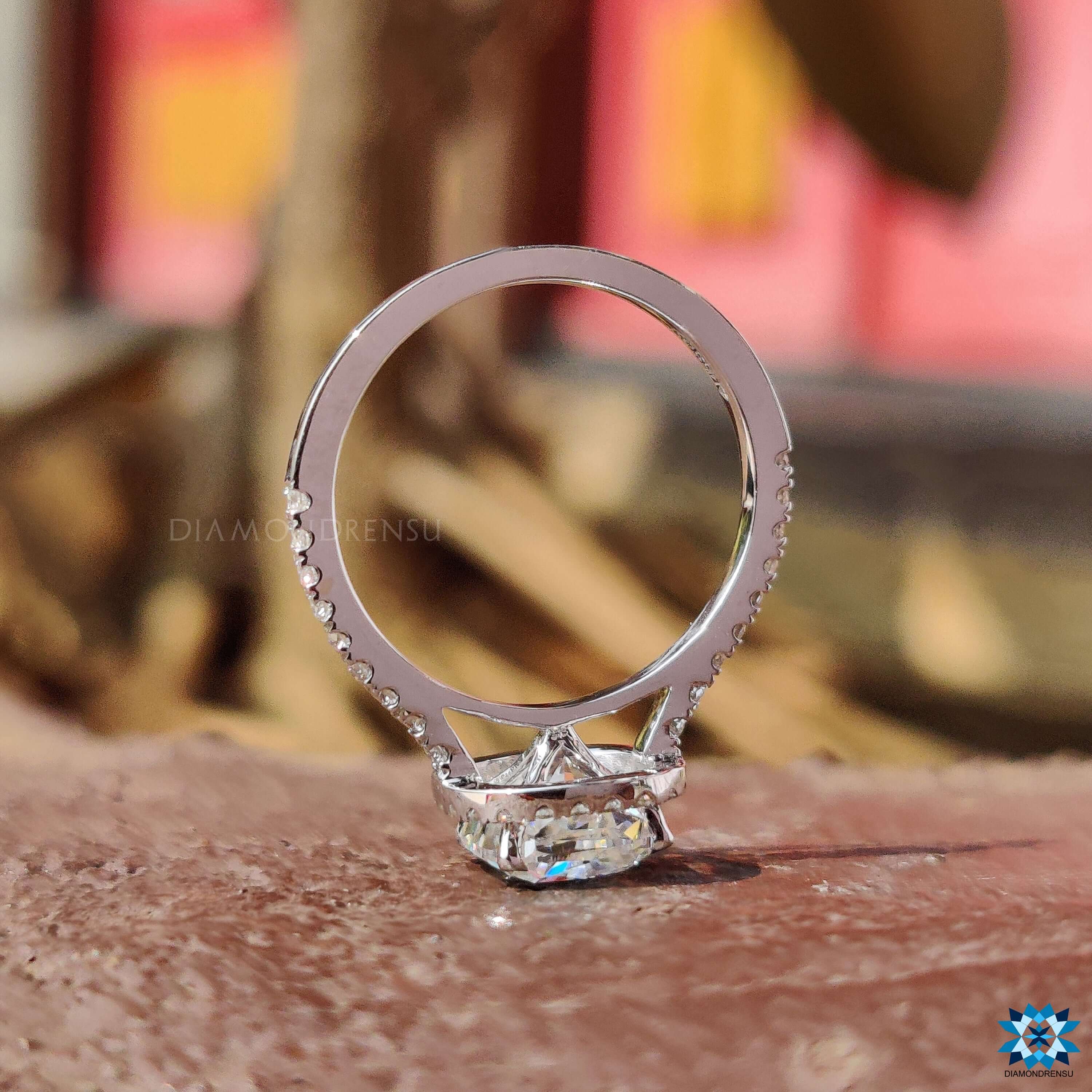 White gold moissanite ring with cushion center and brilliant halo.