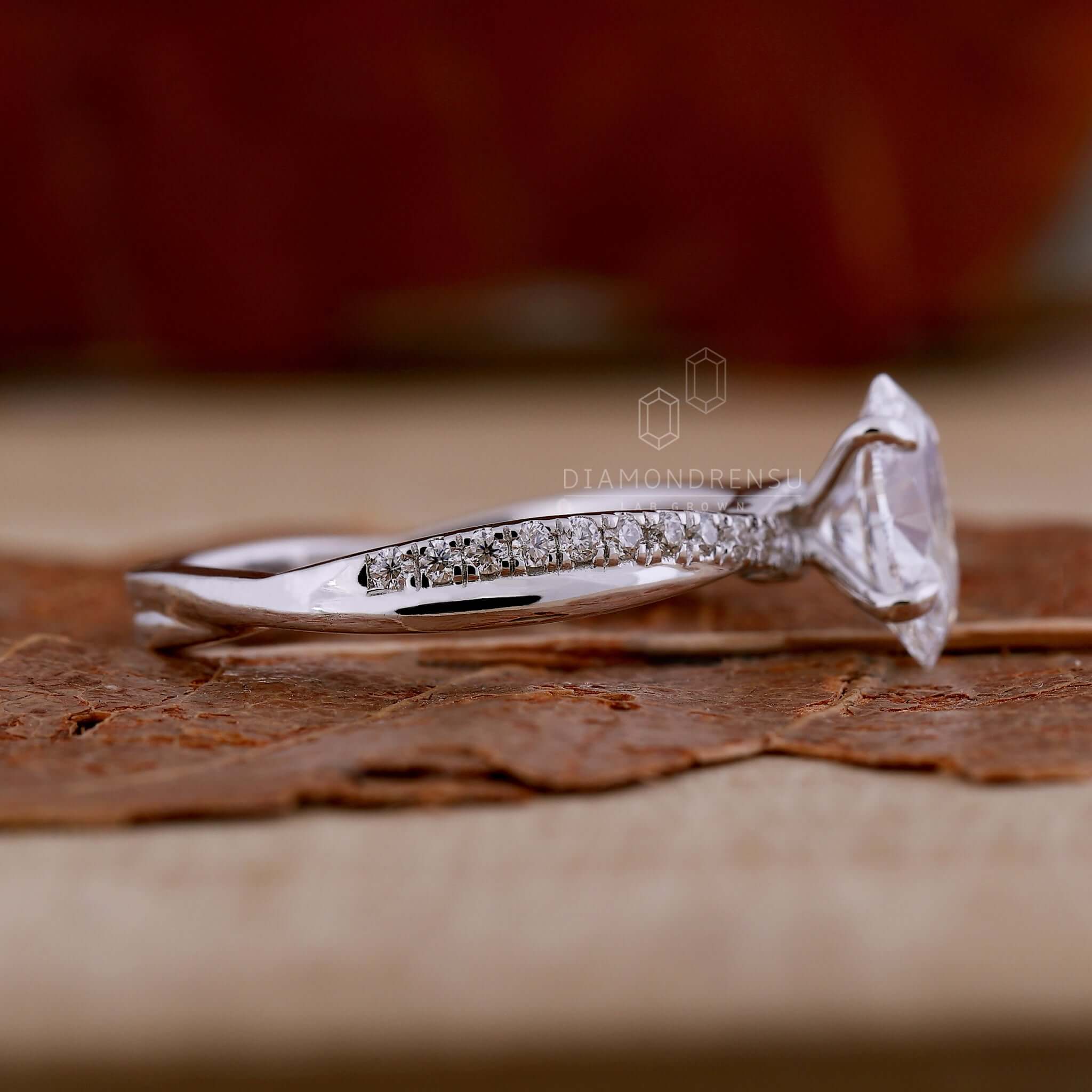 Twisted band engagement ring featuring a pave diamond ring with a claw prong setting for modern elegance.