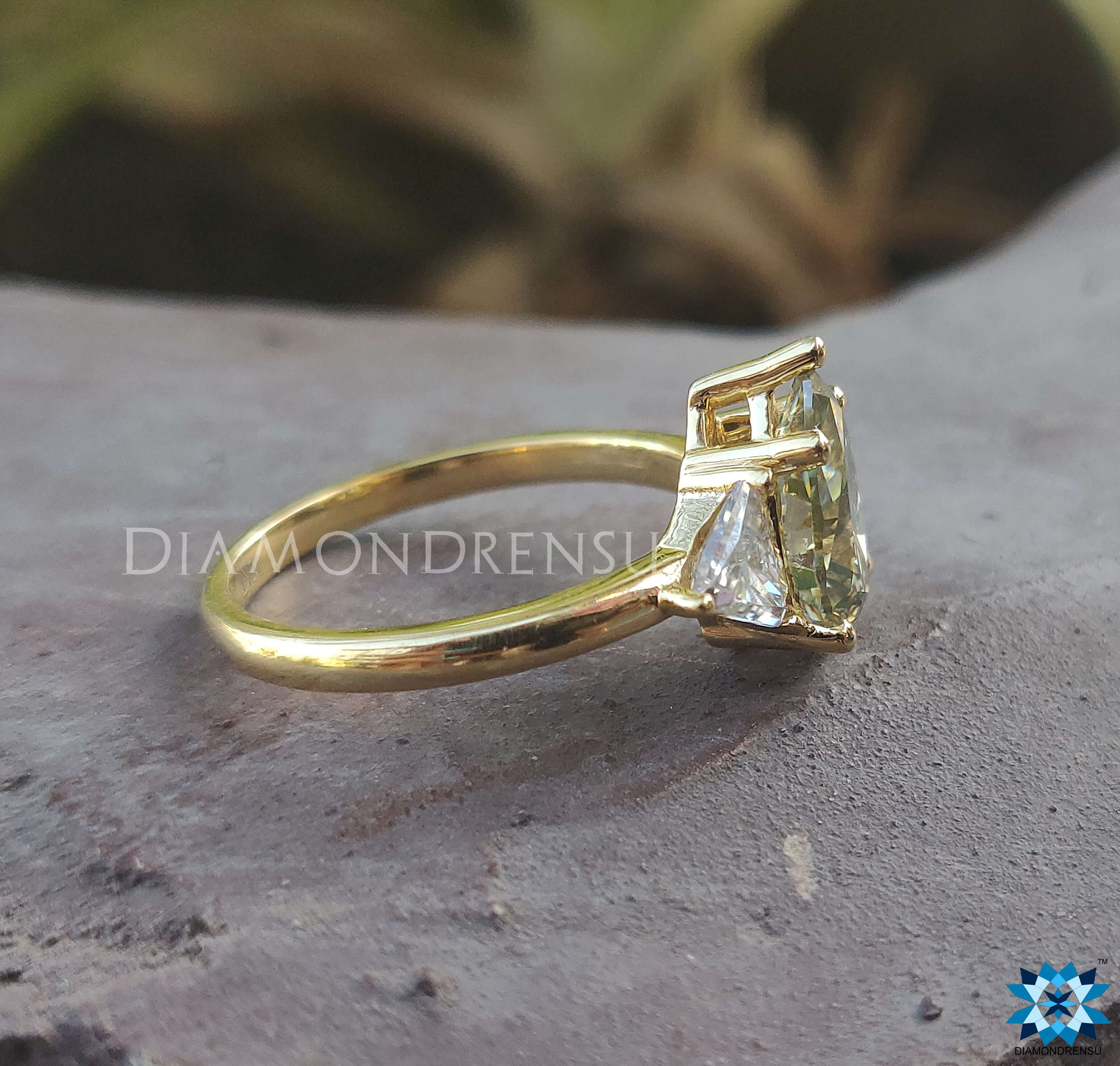 Moissanite ring UK design featuring pear shaped and triangle stones.