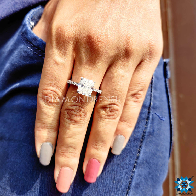 Moissanite engagement ring with trellis setting and round pave design.