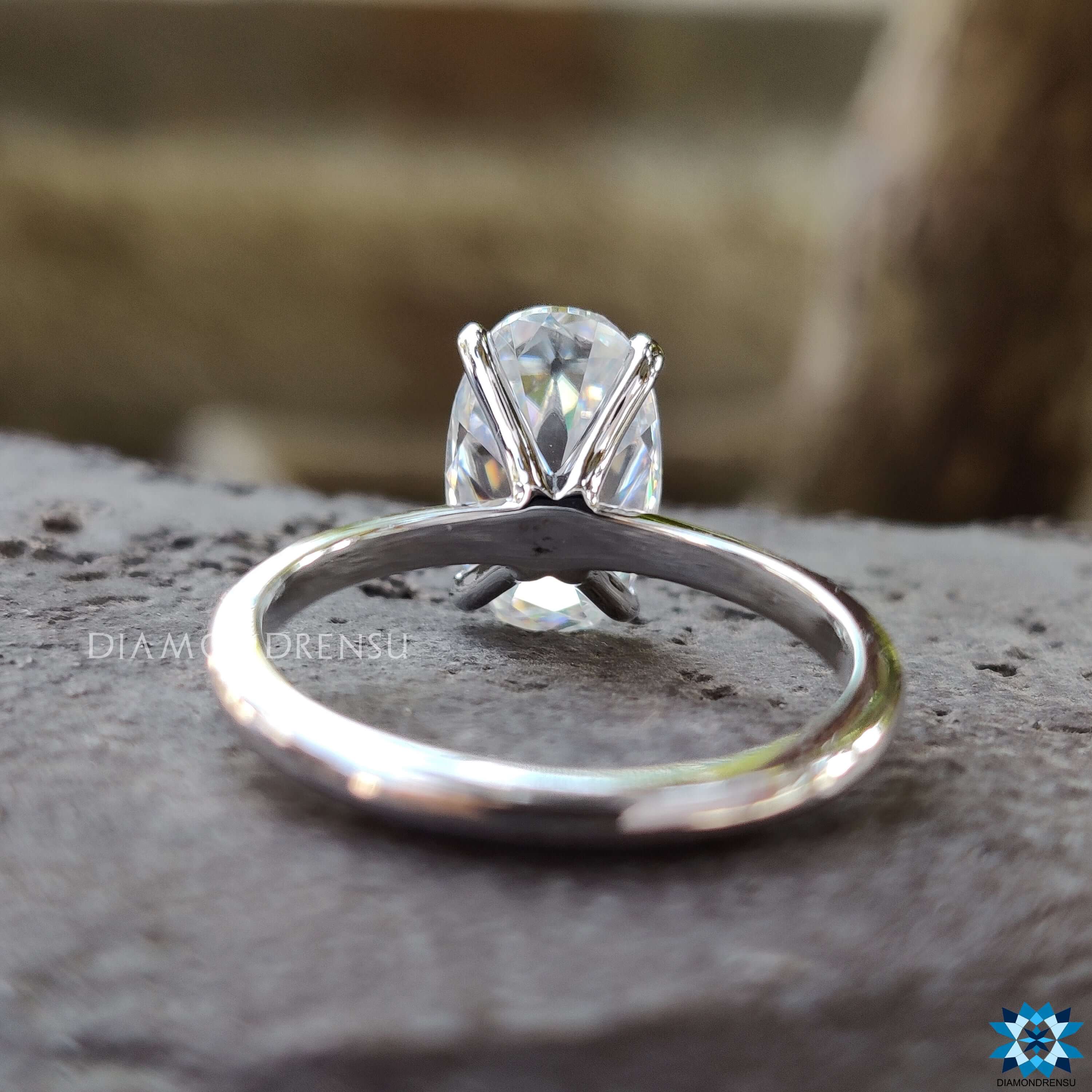 Solitaire ring with Moval cut moissanite and four prong setting.