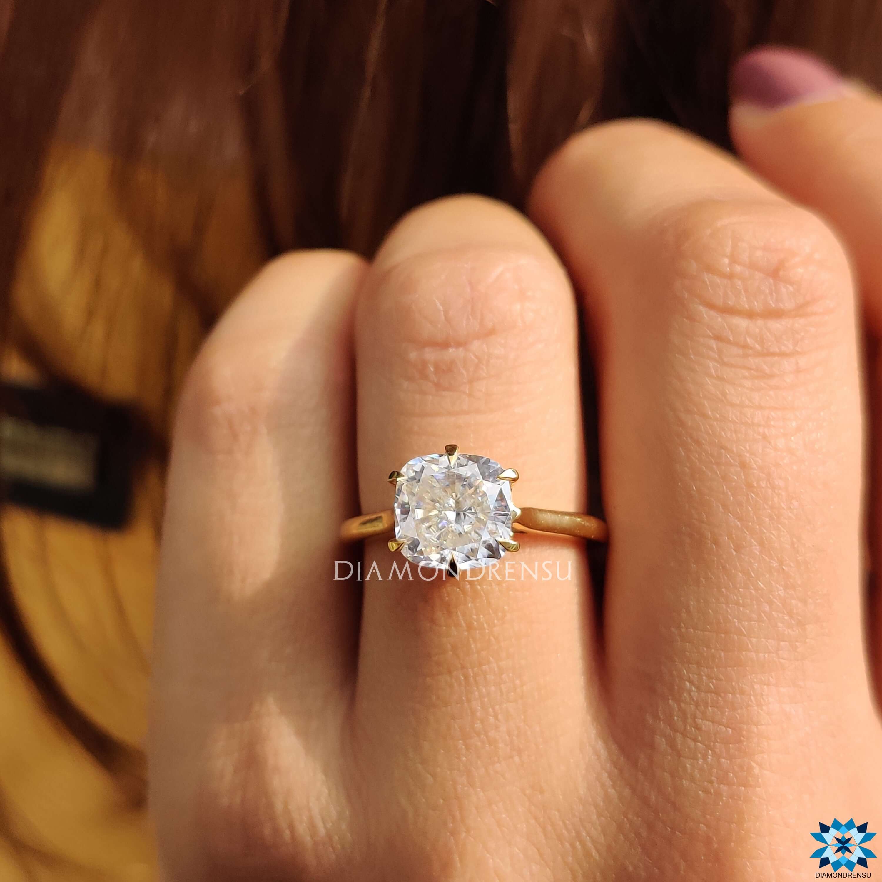 Yellow gold engagement ring with cushion moissanite center.