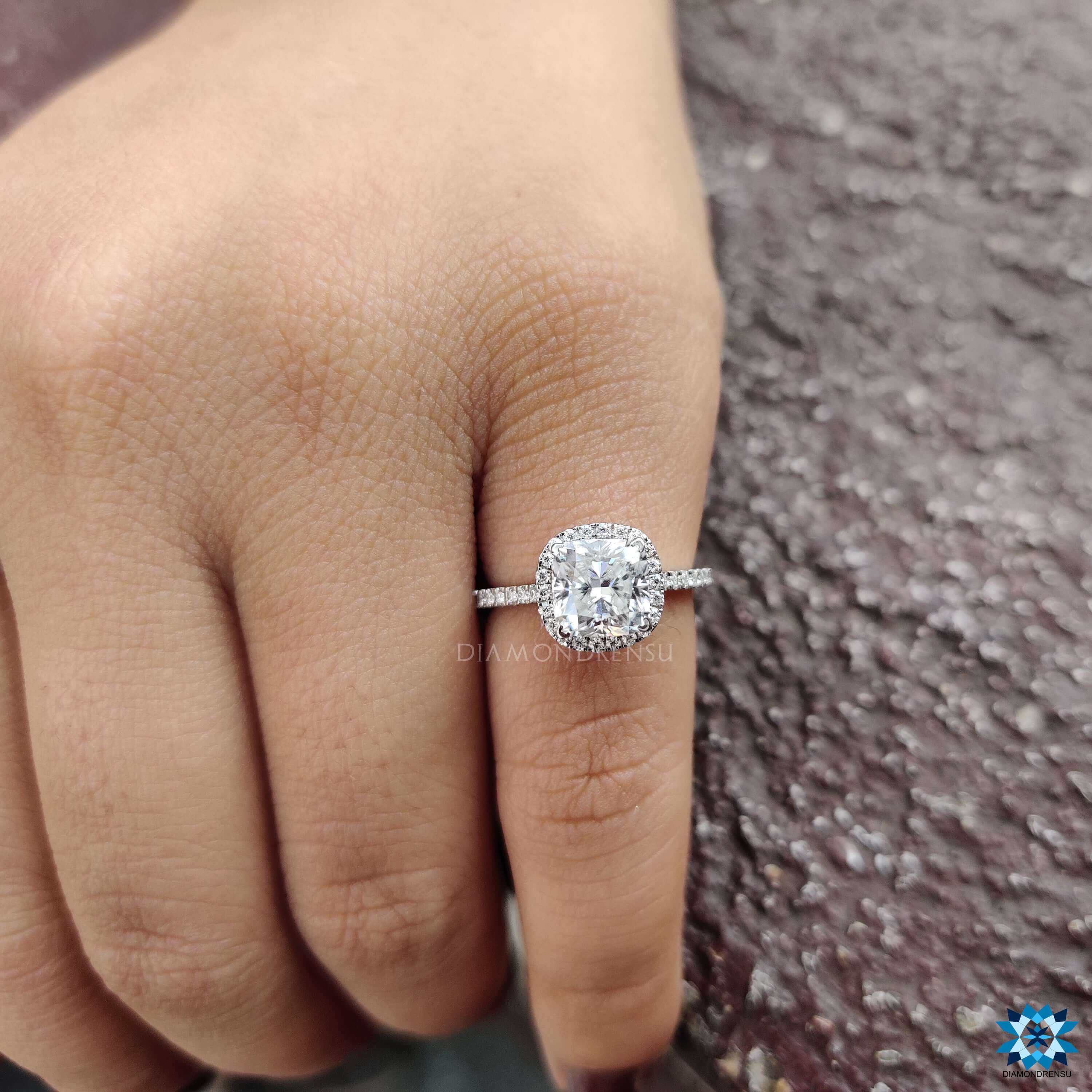 White gold cushion cut ring with cathedral setting and pave halo.