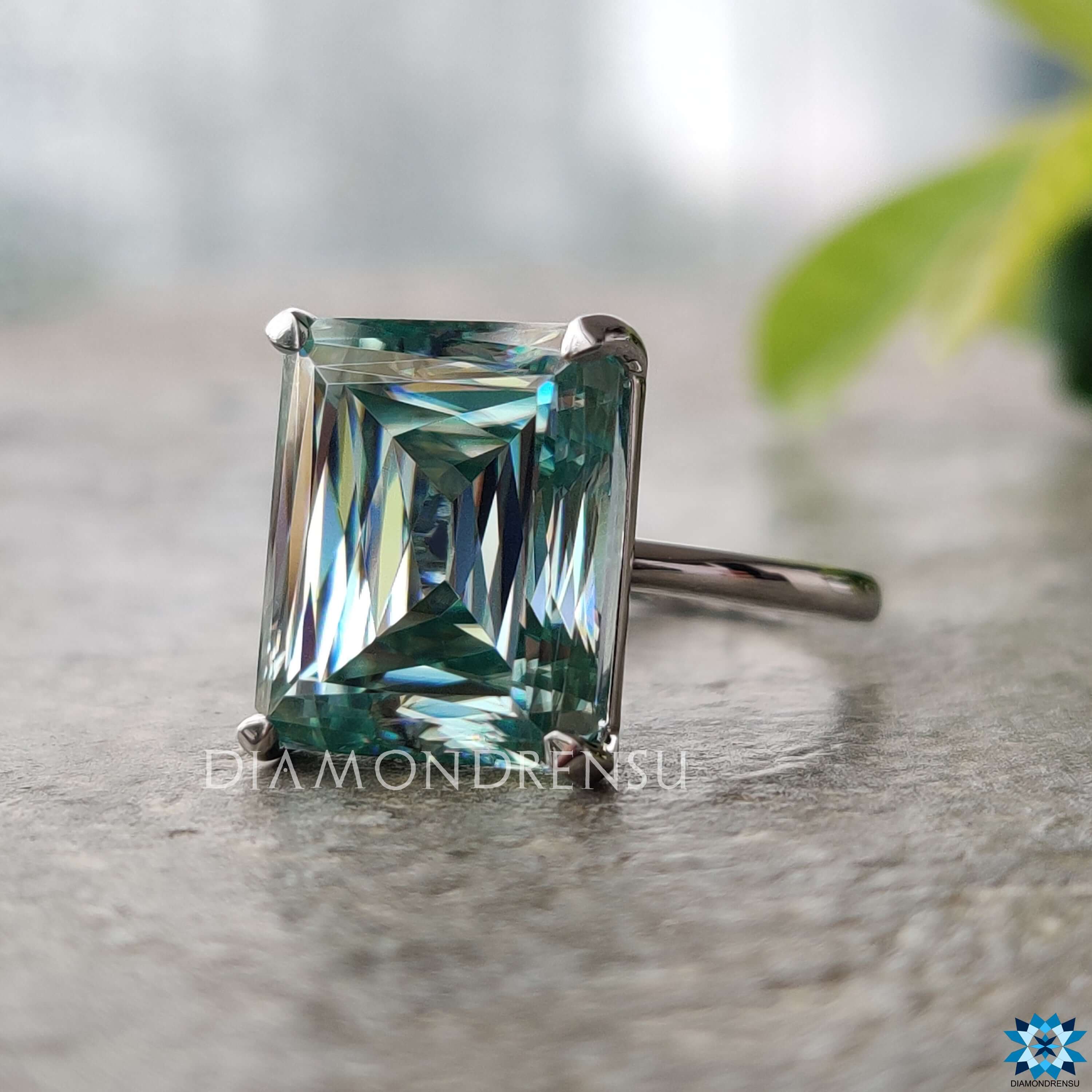Solitaire setting ring with cyan blue criss cut moissanite in white gold.