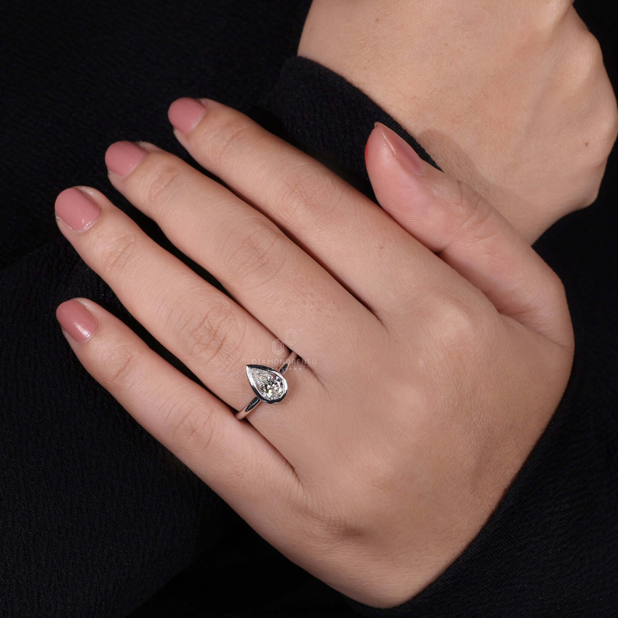 Pear diamond engagement ring paired with a white gold band for a classic look