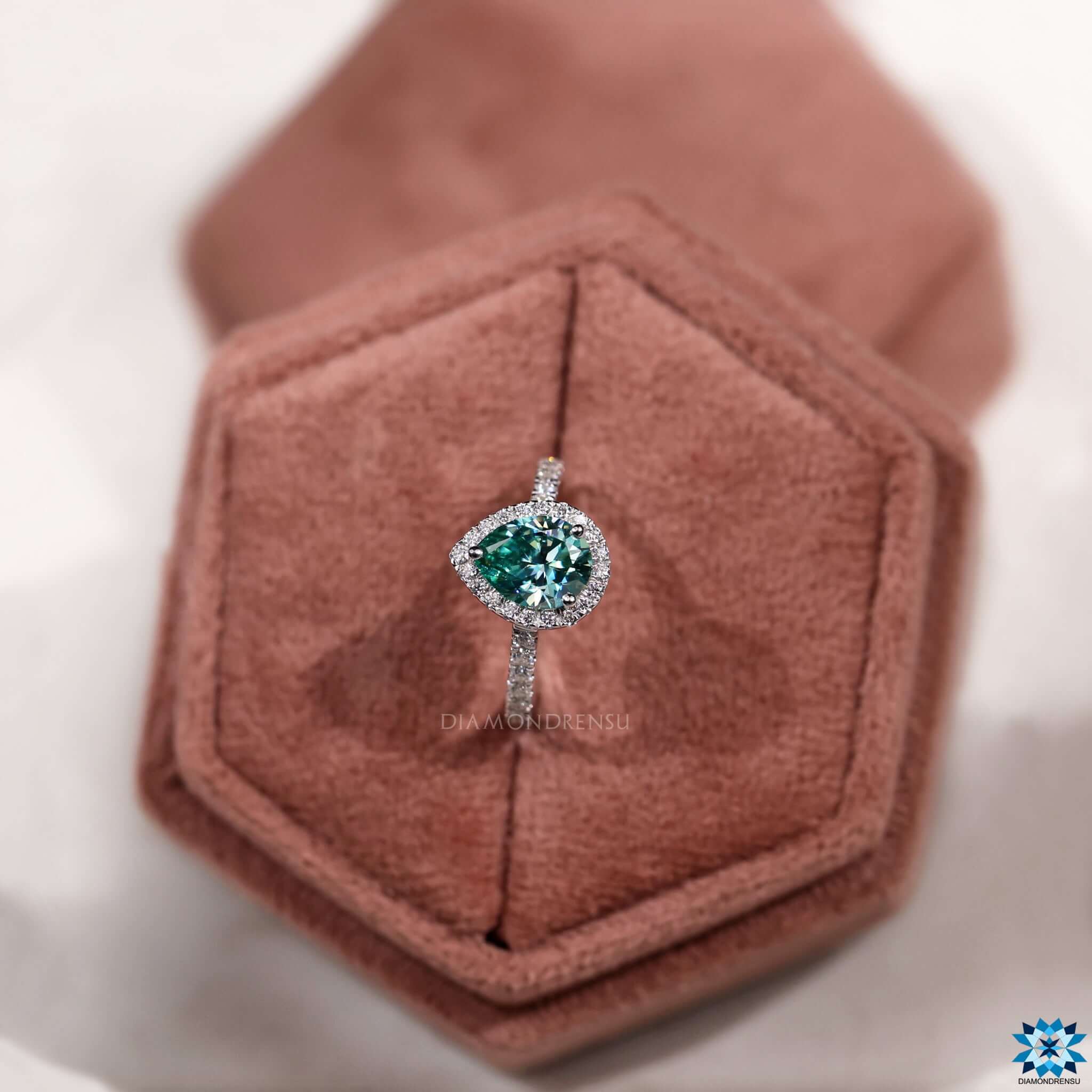 Custom engagement ring with pear shaped moissanite and halo detail.