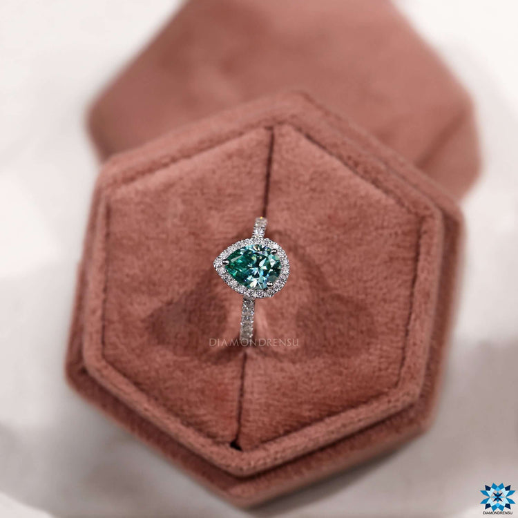 Custom engagement ring with pear shaped moissanite and halo detail.